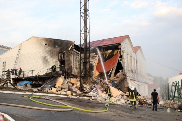 <p>Firemen work to extinguish a fire after the latest missile attack on Kyiv</p>